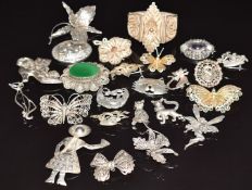 A collection of silver/ white metal filigree brooches and silver cat brooches