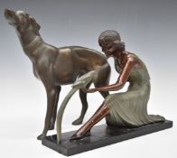 Art Deco style figure of a flapper girl feeding a parrot, together with a large bronze dog,