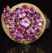 A 9ct gold ring set with rubies in a cluster with rope twist decoration to the shoulder. 8.5g,