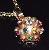 An 18ct gold pendant set with tourmaline, peridot, aquamarines, etc on 9ct gold chain, 47cm long,