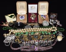 A collection of jewellery including silver bangle, jade brooch, £5 coin, jade necklace, diamanté,