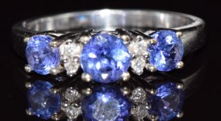 An 18k white gold ring set with three tanzanites and diamonds, 3.8g, size N