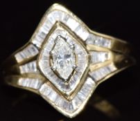A 14k gold ring set with a marquise cut diamond of approximately 0.28ct and further baguette cut