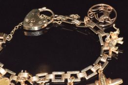 A 9ct gold charm bracelet with five 9ct gold charms comprising a bunch of bananas, turtle, horseshoe