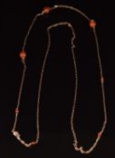 A yellow metal necklace made up of fancy links set with agate beads, 6.3g, 52cm long