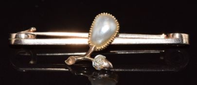 A c1900 9ct gold brooch set with three rose cut diamonds and a split pearl in a foliate/ acorn
