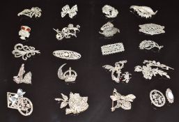 Twenty silver brooches set with marcasite including a crown, heart, lady walking her dog, bow,