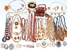 A collection of amber necklaces and bracelets and cameo brooches