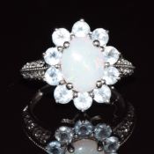 A 9ct gold ring set with an opal and tanzanites, 2.8g, size J