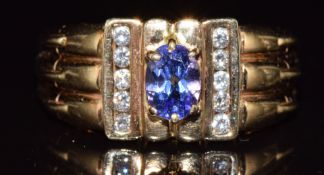 An 18ct gold ring set with an oval tanzanite of approximately 0.6ct and diamonds, 9.8g, size V