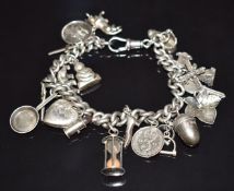 A silver charm bracelet with 19 silver charms including St Christopher, bull, windmill, acorn,