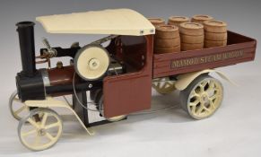 Mamod live steam wagon with brown and cream body and wooden barrels.