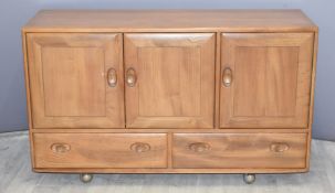 Ercol light elm sideboard fitted three cupboard doors and two drawers, L129 x D45 x H76cm