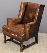 Leather wingback armchair with studded decoration and turned wood legs, width 74cm