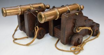 Pair of desk or signalling cannon with 11.5 inch graduated bronze barrels, each raised on a mahogany