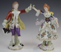 A pair of Sitzendorf figures holding flowers, height 21cm