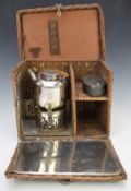 Early 20thC travel or picnic spirit kettle in fitted wicker basket with fold down front, 'En