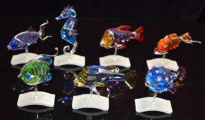 Seven Swarovski Crystal Paradise coloured glass tropical fish all raised on wave bases, the seahorse