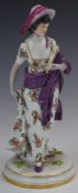 Meissen figurine of a lady holding a fan with lilac wrap and floral dress, impressed marks to base