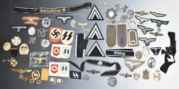 Small collection of replica German Nazi Third Reich cloth and metal badges, insignia etc