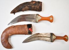 Two Middle Eastern Jambiya daggers with amber or similar handles, both with leather covered sheaths,
