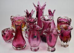 Twelve Bohemia and Murano style cranberry glass vases, largest 31cm tall.