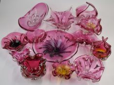 Thirteen Bohemia and Murano style cranberry glass bowls and dishes, largest 36cm in diameter.