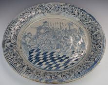 Large Delft charger decorated with an elaborate court scene including harp player, soldier and