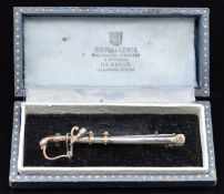 Silver sweetheart brooch in the form of a sword with stirrup hilt and lion head pommel, in box