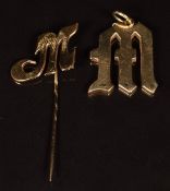 A 9ct gold pendant and stick pin both in the form of a letter 'M', 9.6g