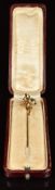 A yellow metal stick pin set with paste and faux pearls in a floral design, in vintage box