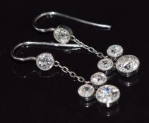 A pair of Art Deco platinum earrings, each set with transitional cut diamonds of approximately 0.