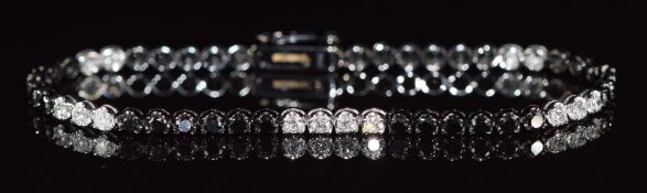 An 18ct gold tennis bracelet set with diamonds and black diamonds, total carat weight