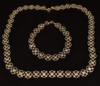 A 14k gold bi-coloured necklace and matching bracelet made up of floral links, 17.2g