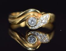 An 18ct gold ring set with diamonds in a twist setting, the largest diamond approximately 0.15ct,