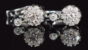A pair of 18k white gold earrings set with diamonds in clusters, the largest diamond approximately