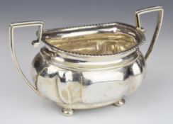 Early 20th century hallmarked silver twin handled sugar bowl with gadrooned edge, raised on four