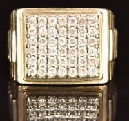 A 9ct gold ring set with cubic zirconia in a rectangular setting with ridged decoration to the