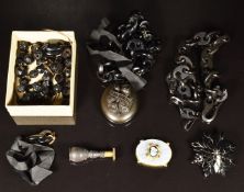 A collection of jet jewellery comprising two chains, a locket with floral decoration and reading 'In