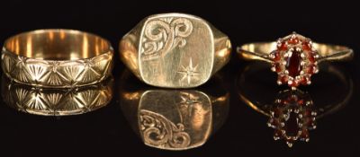 A 9ct gold ring set with garnets, 9ct gold signet ring set with a diamond and a 9ct gold wedding