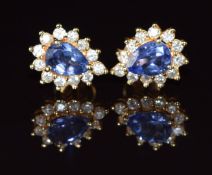 A pair of 18k gold earrings each set with a pear cut tanzanite of approximately 0.5ct surrounded