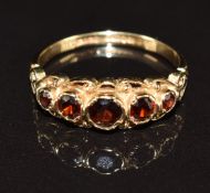 A 9ct gold ring set with five round cut garnets, 2.4g, size O