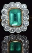 An 18ct gold ring set with an emerald cut emerald measuring approximately 1ct surrounded by 14