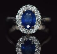 A platinum ring set with an oval cut sapphire of approximately 1.65ct surrounded by diamonds, with