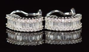 A pair of 18ct white gold clip earrings, each set with fourteen baguette cut and thirteen