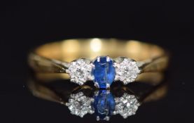 An 18ct gold ring set with a sapphire and two diamonds in a platinum setting, 2.4g, size L