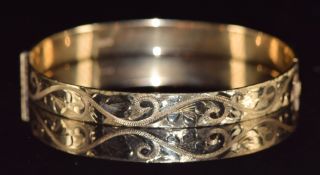 A 9ct gold bangle with engraved decoration, 15.8g