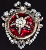 A late Victorian pendant / brooch set with garnet cabochons and old cut diamonds to the centre in