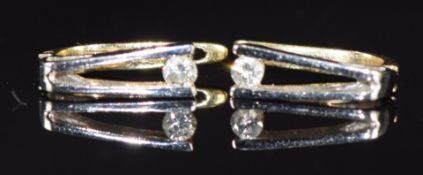 A pair of 14k gold bi-coloured earrings each set with a diamond of approximately 0.07ct, 2.1g