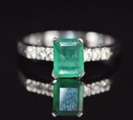 An 18k white gold ring set with an emerald cut emerald of approximately 0.9ct and diamonds to the